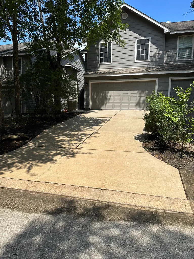 Concrete driveway slabs leading to a home with gray siding and garage