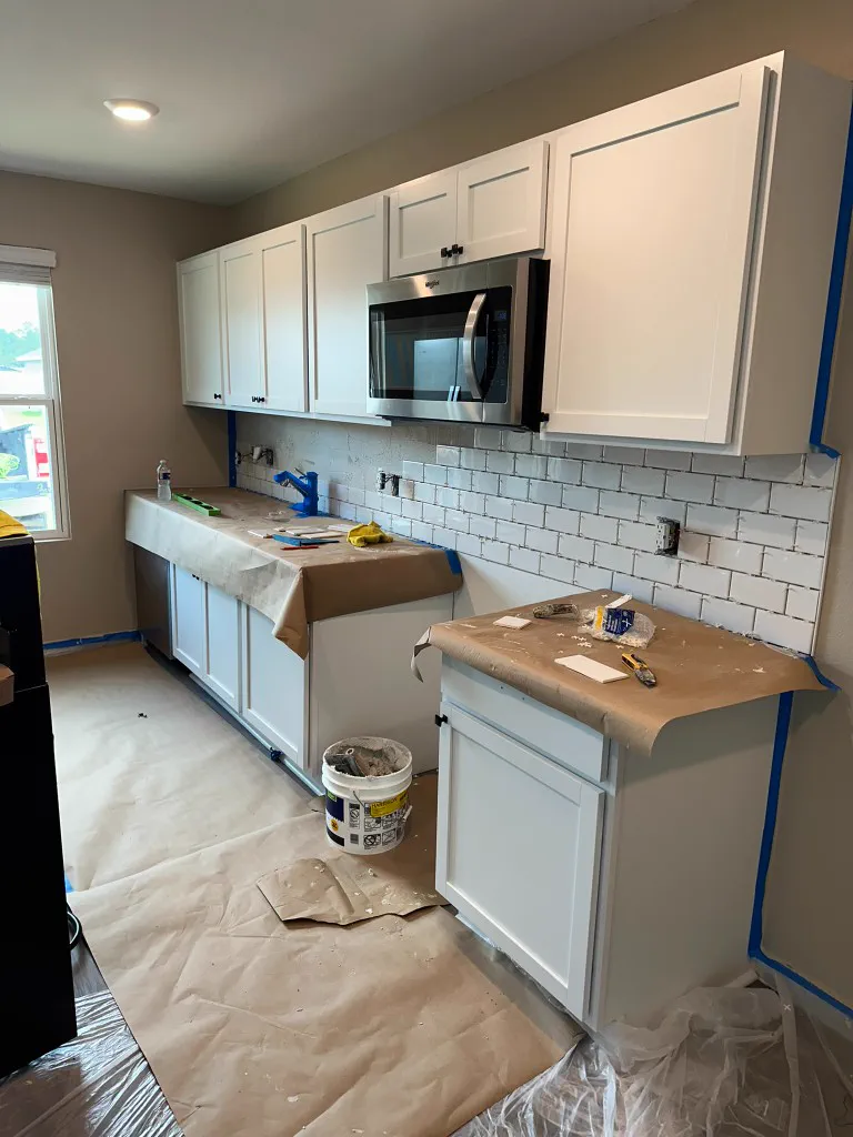 Kitchen remodel with subway tile backsplash, microwave, and protected countertops
